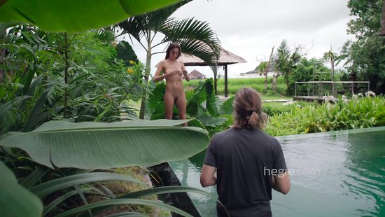 Stunning girl poses near a pool for a cameraman